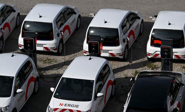A row of electric cars lined up and charging in the street
