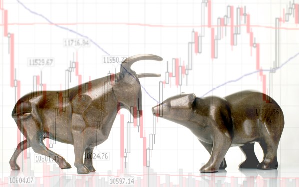 An image of a bull and bear in front of a stock market chart
