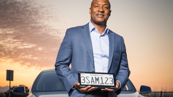 man holding license plate
