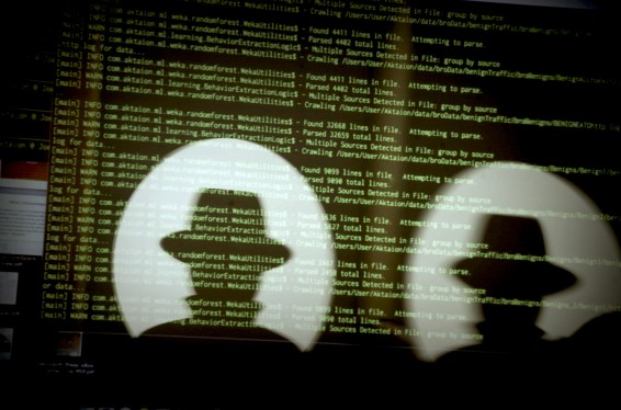 Green code text on a silhouette of Black Hat and Def Con logos.