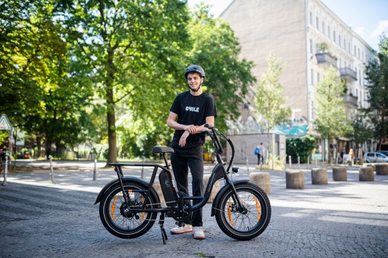 teenage boy wearing black tshirt that says 'cycle' standing behind rad power bikes e-bike