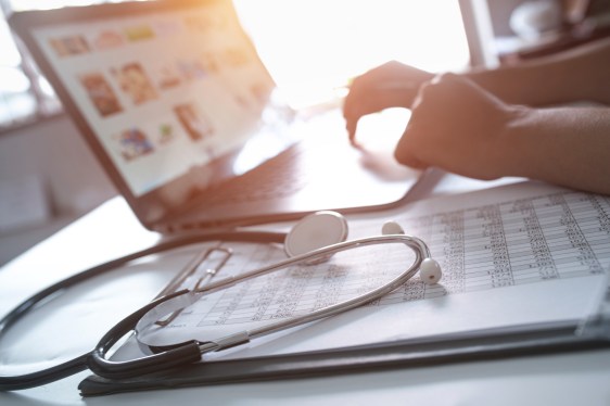 Close-up of hands of a nurse typing on laptop, used in post about startup CoverSelf