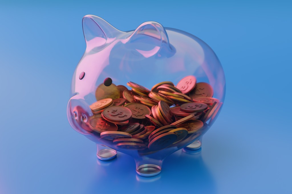 transparent piggy bank half full of coins