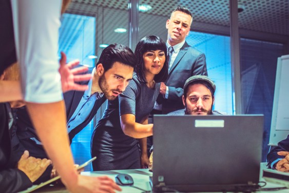 Group of people gathered around a computer during a business crisis.