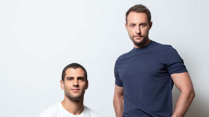 2 men; 1 sitting, 1 standing