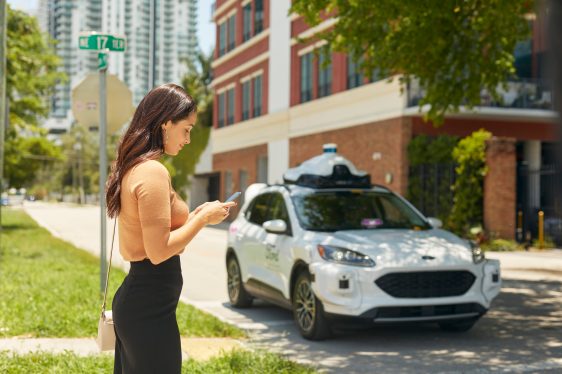 woman hailing autonomous taxi