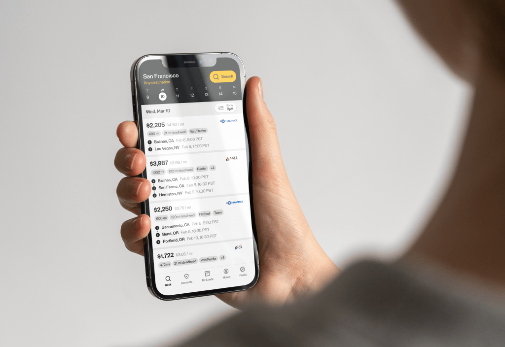 smartphone being held by person displaying truck load board platform