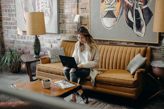 Woman working on a laptop on her sofa, used in post about edtech startup Virtual Internships