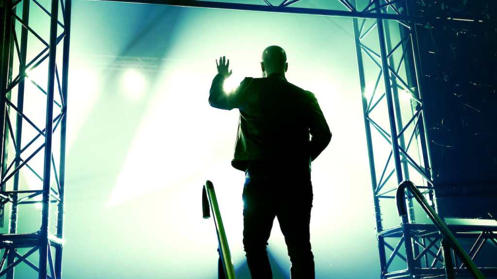 man entering foggy, lighted stage