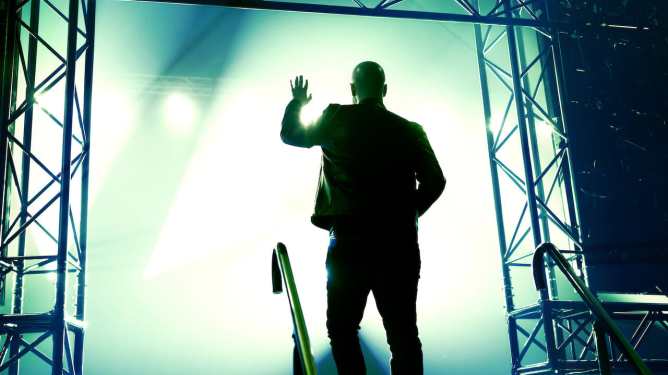 man entering foggy, lighted stage