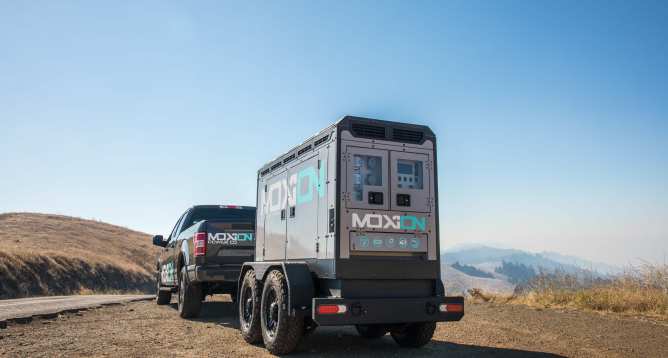A Moxion Power battery generator hooked up to a pickup truck.