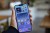 a hand holding Apple’s iPhone 14 Plus