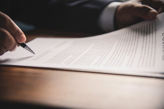 Hand holding pen signing contract