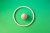 Image of one wooden sphere in the middle of one wooden circle on green background.