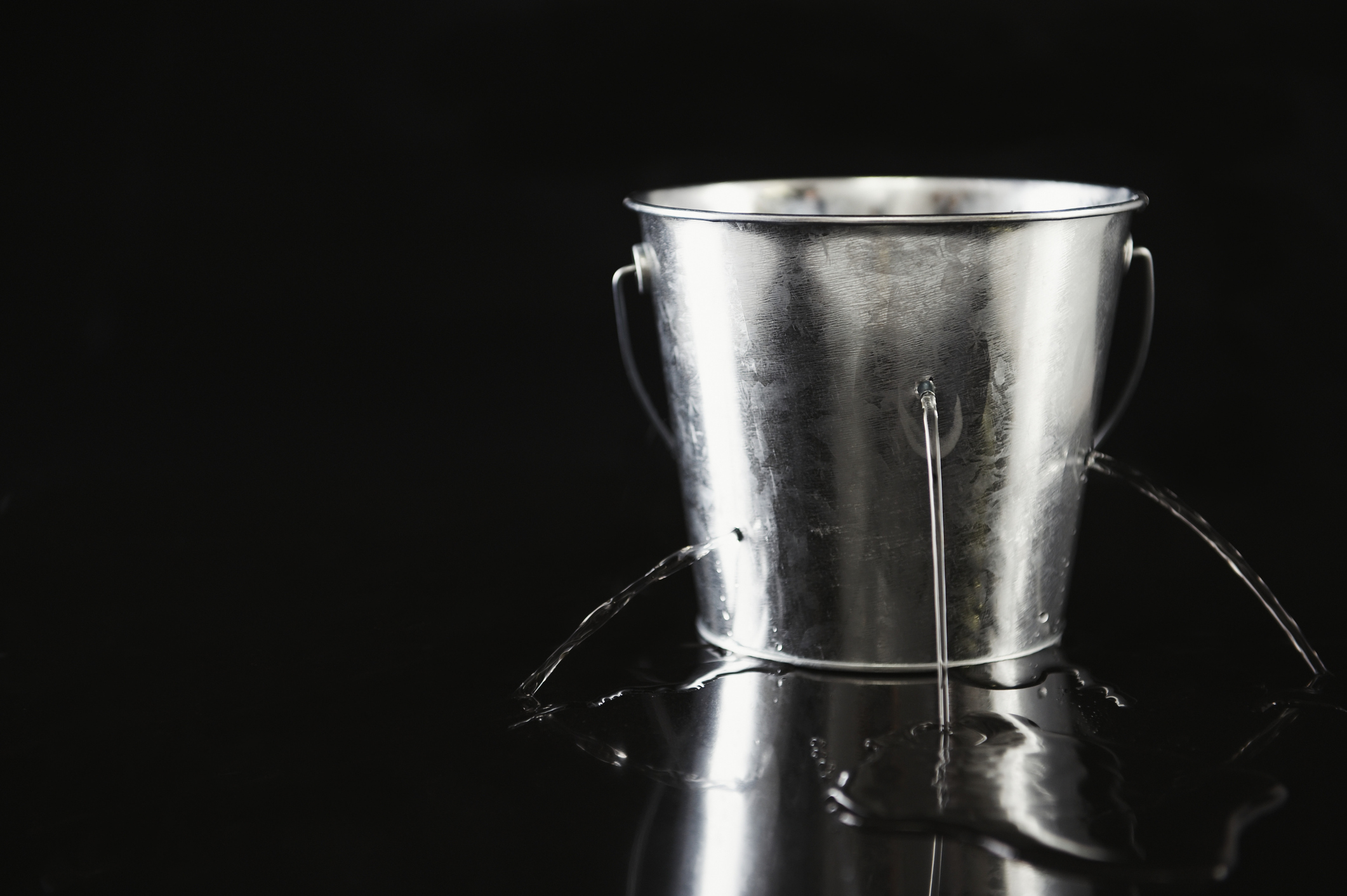 Water pouring out of holes in bucket