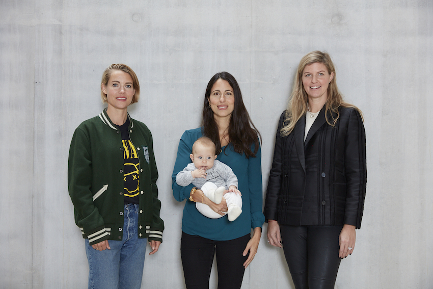 3 women standing, one holding a baby