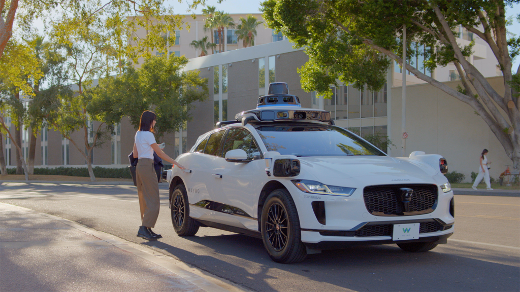 woman hails waymo robotaxi in downtown phoenix
