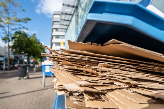 Used flattened cardboard boxes in a recycling container