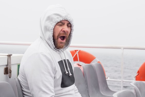 Yawning man seated on a boat