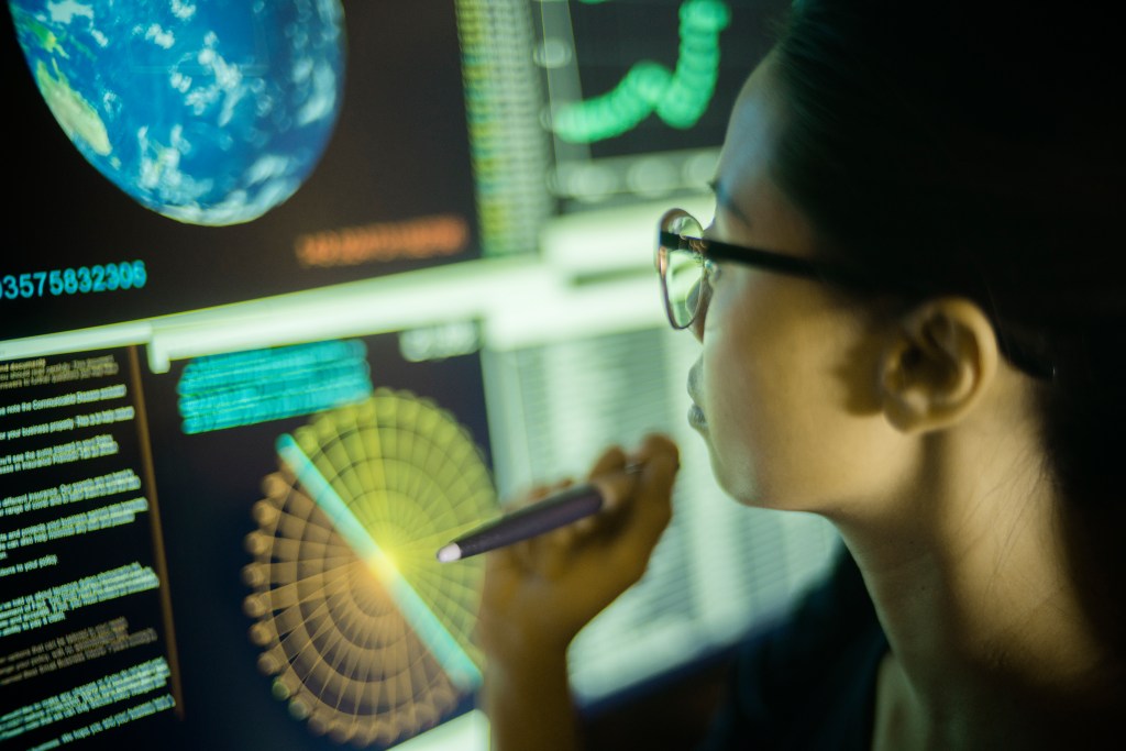 Woman looking at a screen of Earth monitoring data.