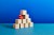 A stack of plain wooden blocks with two unusual red blocks supporting the edge