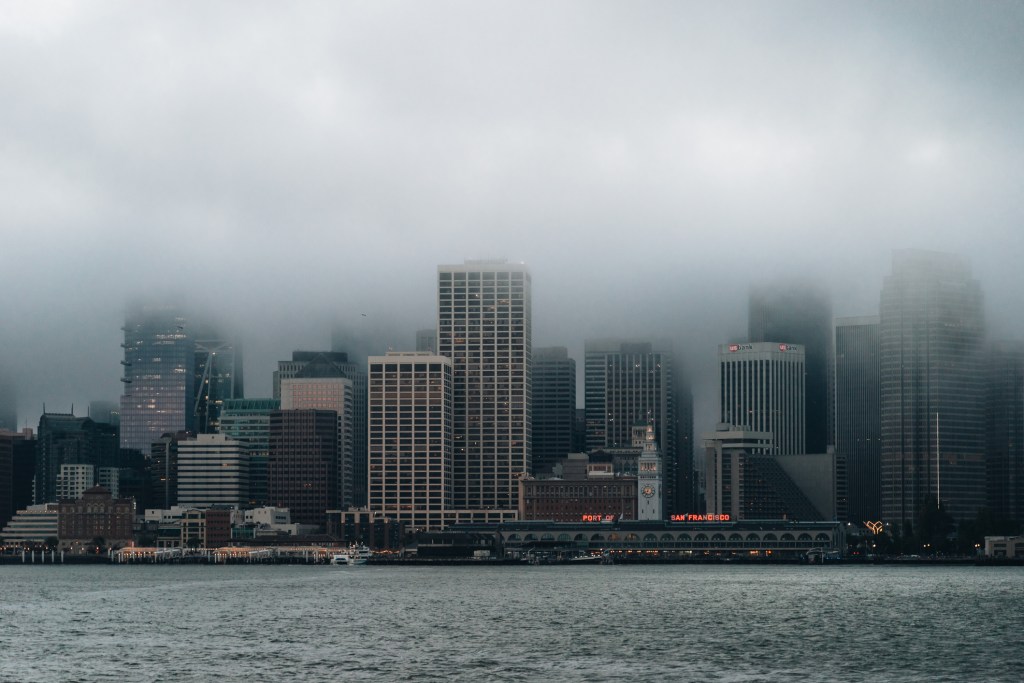Skyline of SF partially covered in low-hanging clouds.