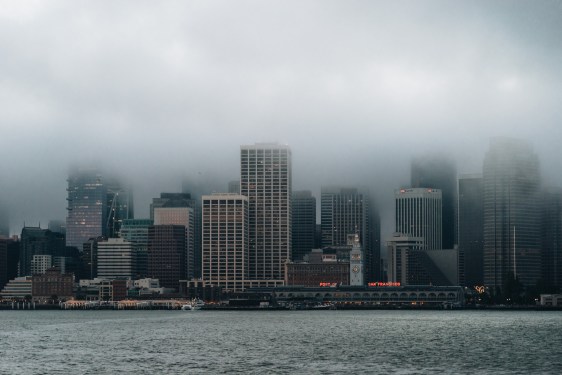 Skyline of SF partially covered in low-hanging clouds.
