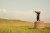 A young British boy in a business suit is standing on a pedestal looking through a hand-held telescope in the English countryside. He is looking for more business opportunities.