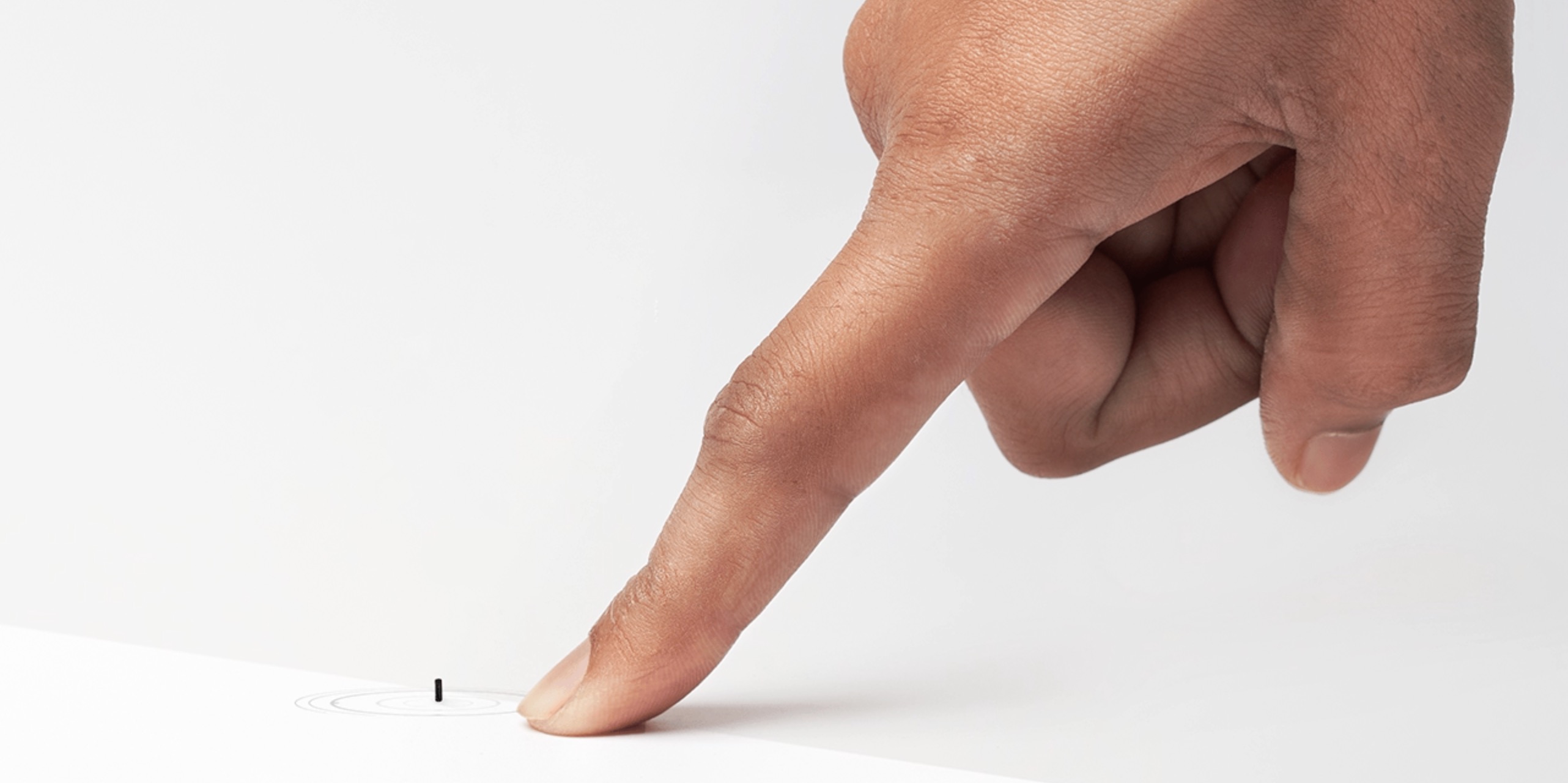 finger pointing at a tiny, remote-controlled medical robots