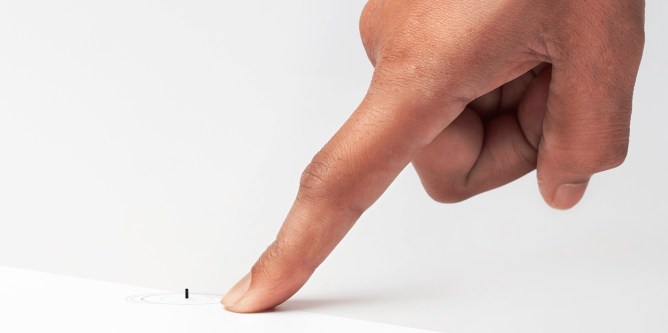 finger pointing at a tiny, remote-controlled medical robots