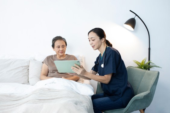 A Speedoc healthcare provider and patient looking at a tablet