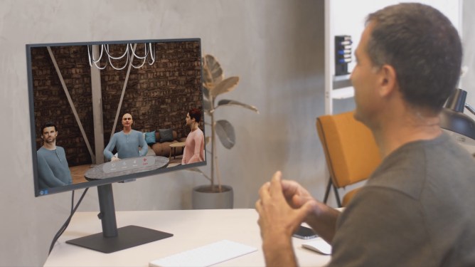 man sitting in front of computer screen on which there are three avatars seated around a conference table