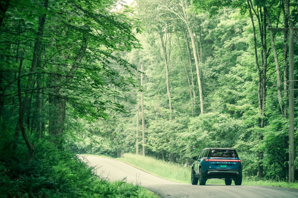 Rivian R1S on a forested road