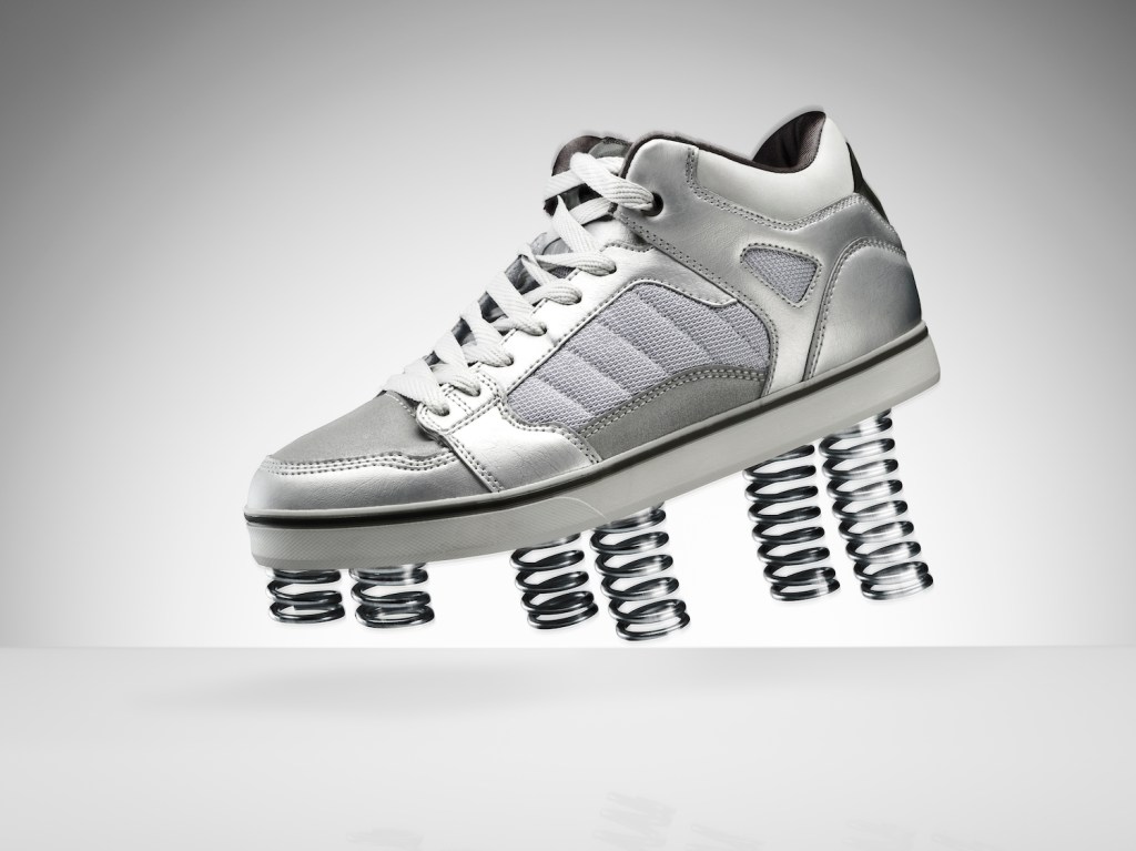A sports shoe jumping in the air with springs on the bottom