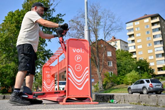 A fleet specialist at Voi Technology AB replaces public hire electric scooters at a designated parking area in Stockholm, Sweden.