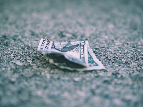 Old dollar bill crumpled on road