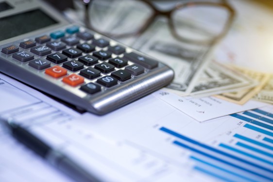 Photo of a calculator, pen and summary report, used in post about corporate services super app Osome.