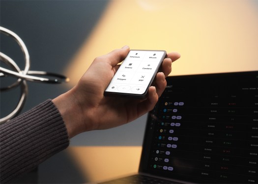 An image of the Ledger Stax crypto hardware wallet in a person's hand