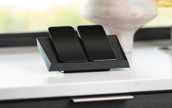 Tesla wireless charging station with 2 mobile phones on it