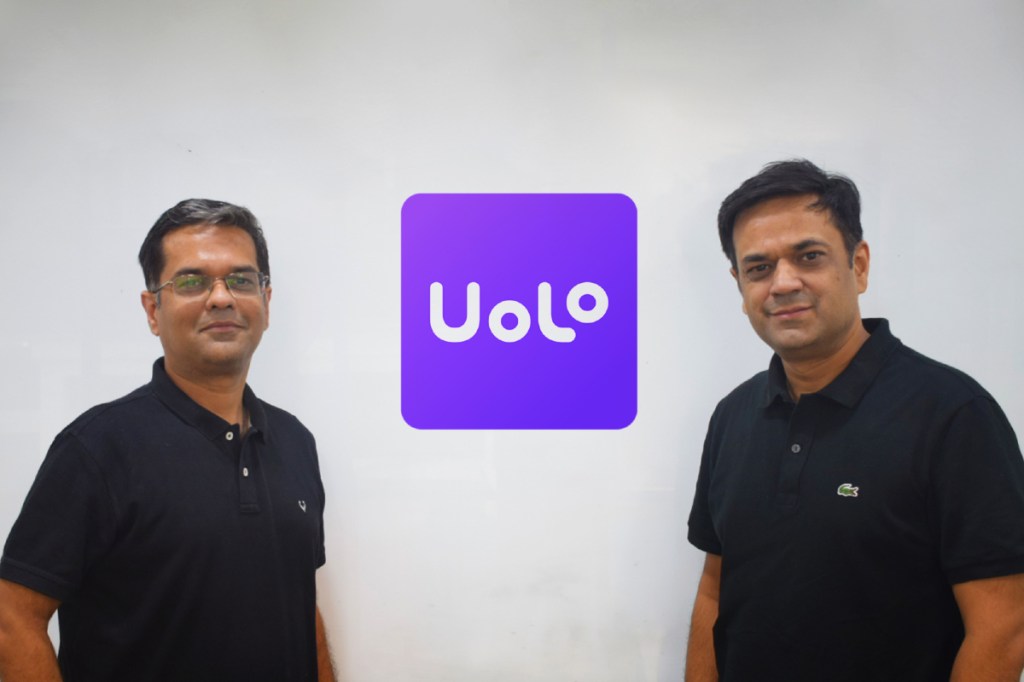 two men standing by Uolo sign