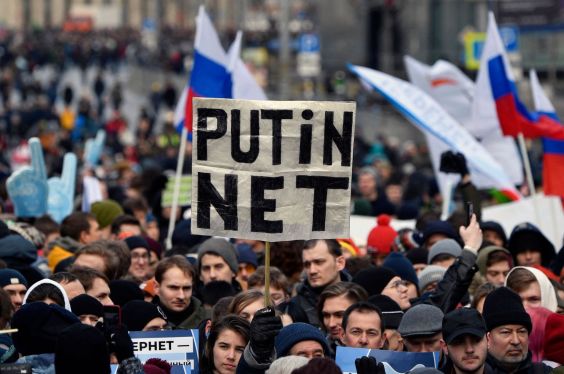 a protest in Russia with someone holding a sign saying "PUTIN NET"