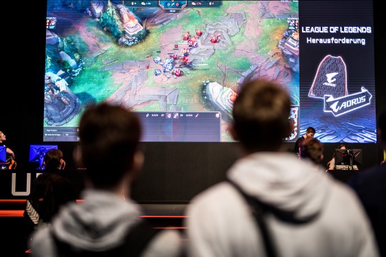 two players watching League of Legends on a big-screen at a gaming event in Germany