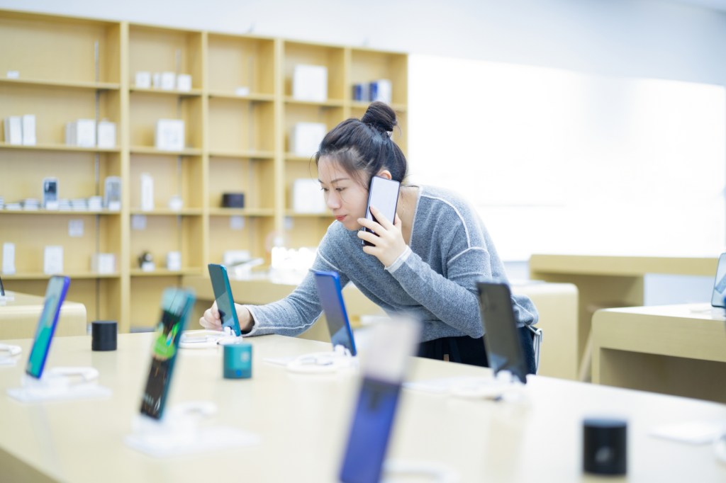 Young woman shopping for a smartphone.