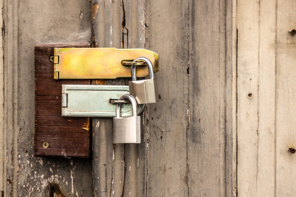 Two padlocks lock an old door