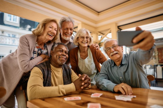 A group of seniors taking a selfie at a table, used in a post about the a2 Collective's Pilot Awards