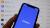 Coinbase's logo on a phone in front of crypto prices