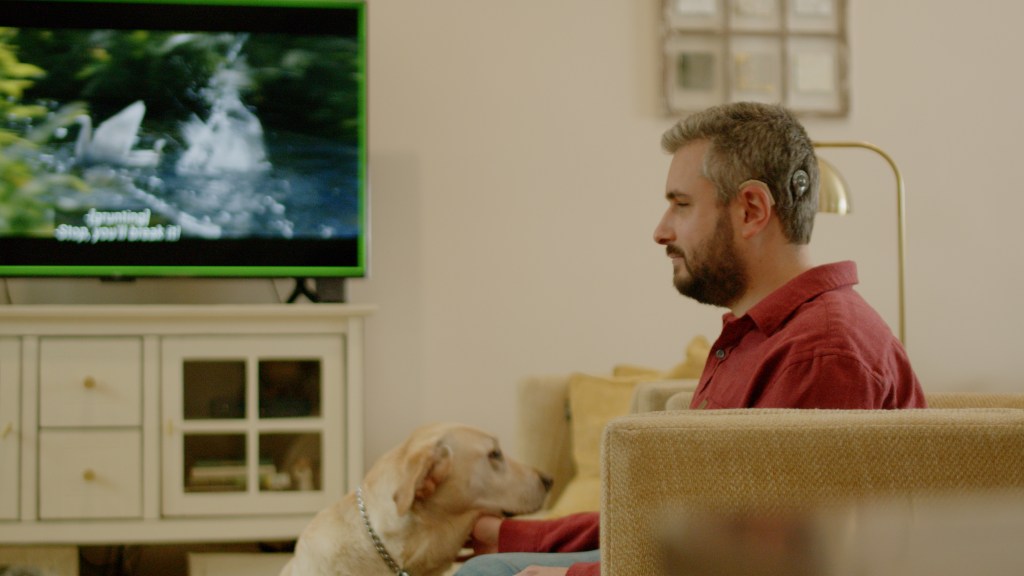 Man with Cochlear hearing implants watching TV