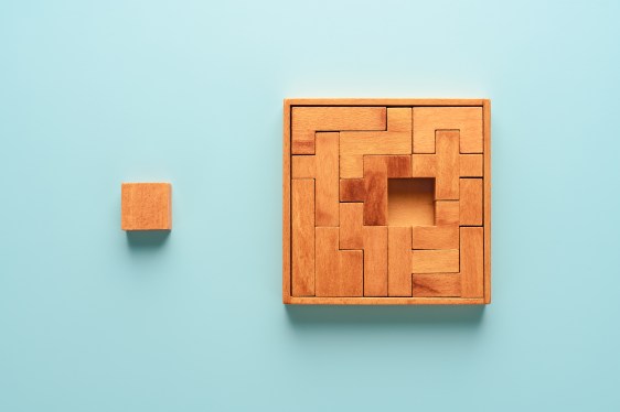Image of a wooden puzzle with one missing piece on a blue background.