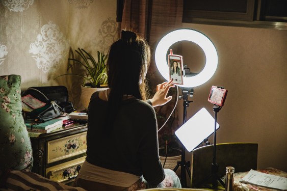 female influencer filming content using phone in a bedroom