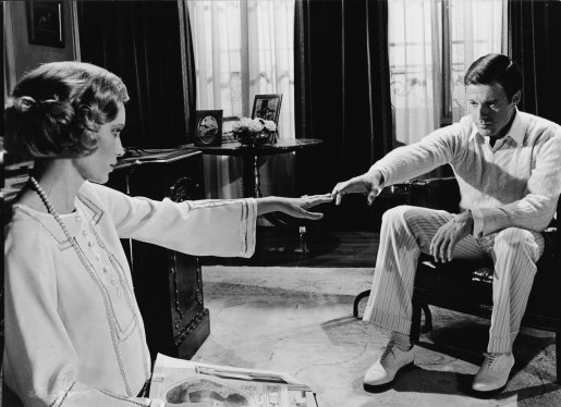 Mia Farrow, as Daisy Buchanan, and Robert Redford, as Jay Gatsby, reach for one another across a room in a scene from 'The Great Gatsby,'